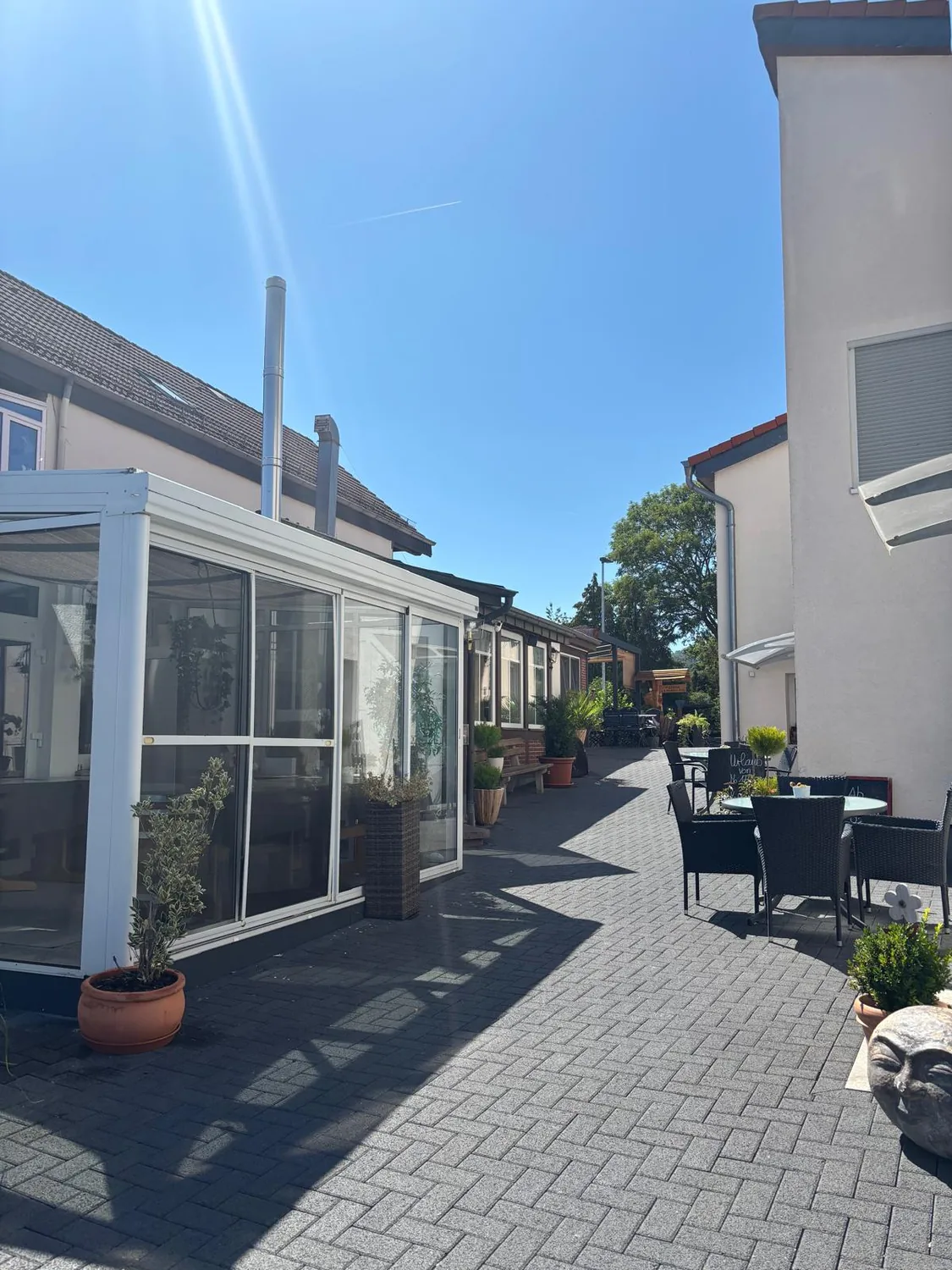 Außenbereich des La Mamma Mia mit Wintergarten und Terrasse an einem Sommertag