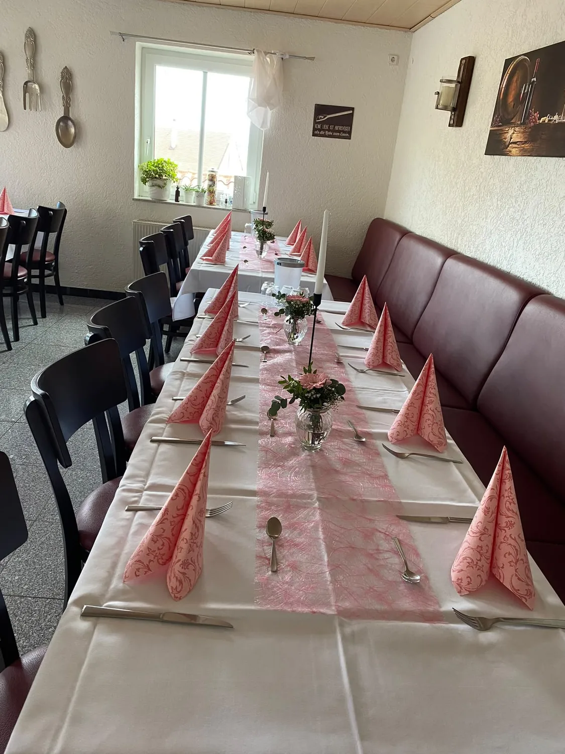 Heller Gastraum mit langer, festlich eingedeckter Tafel